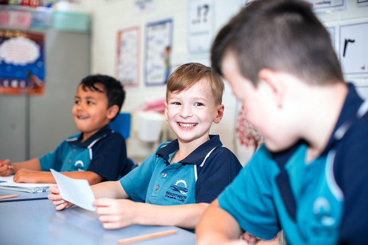 two students smiling learning guitar